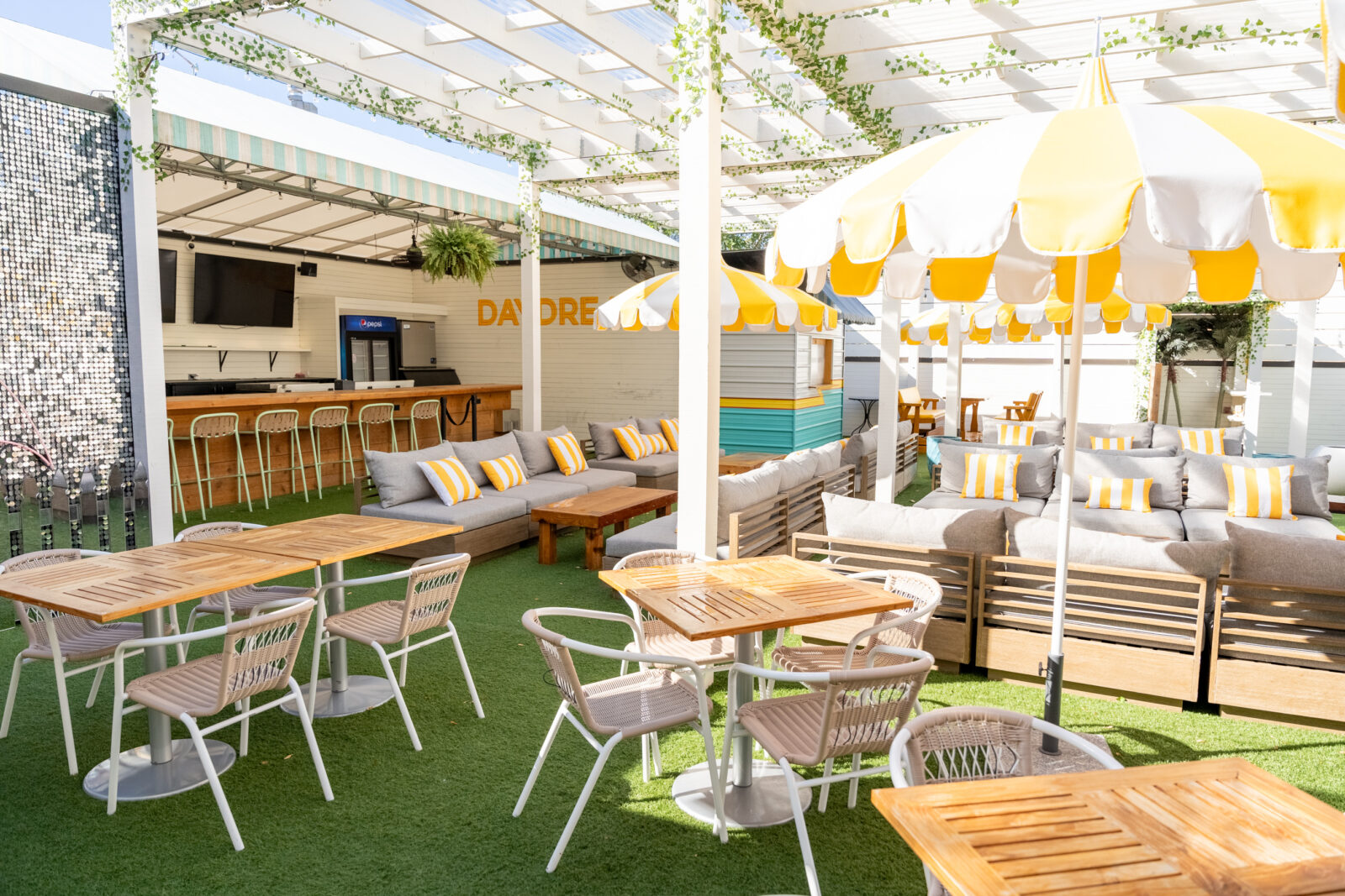 slide 1 of 2 - Rooftop space, couch and low top table seating. Bar area.