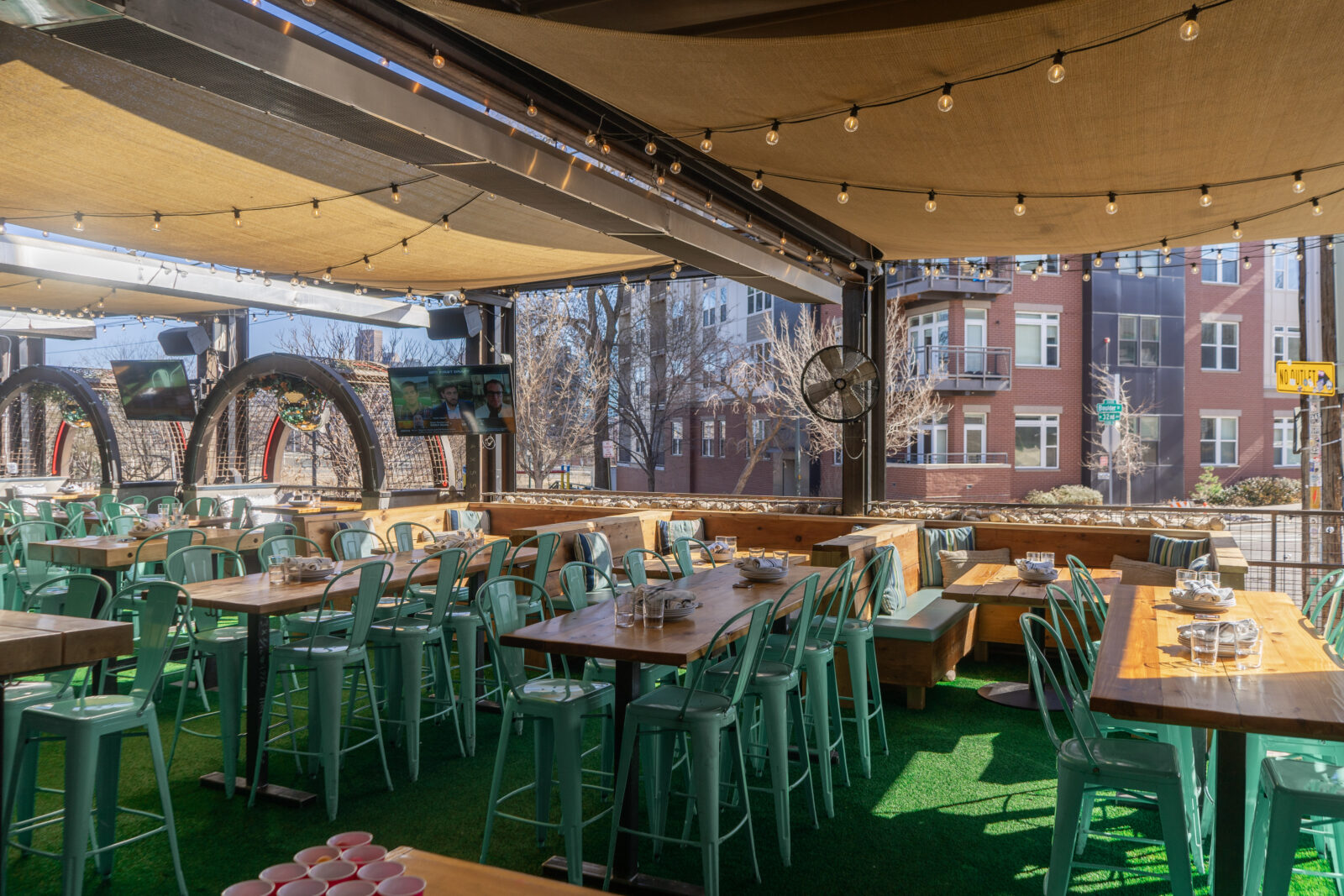 slide 3 of 3 - Open air patio, retractable roof, long high top tables and low top booths