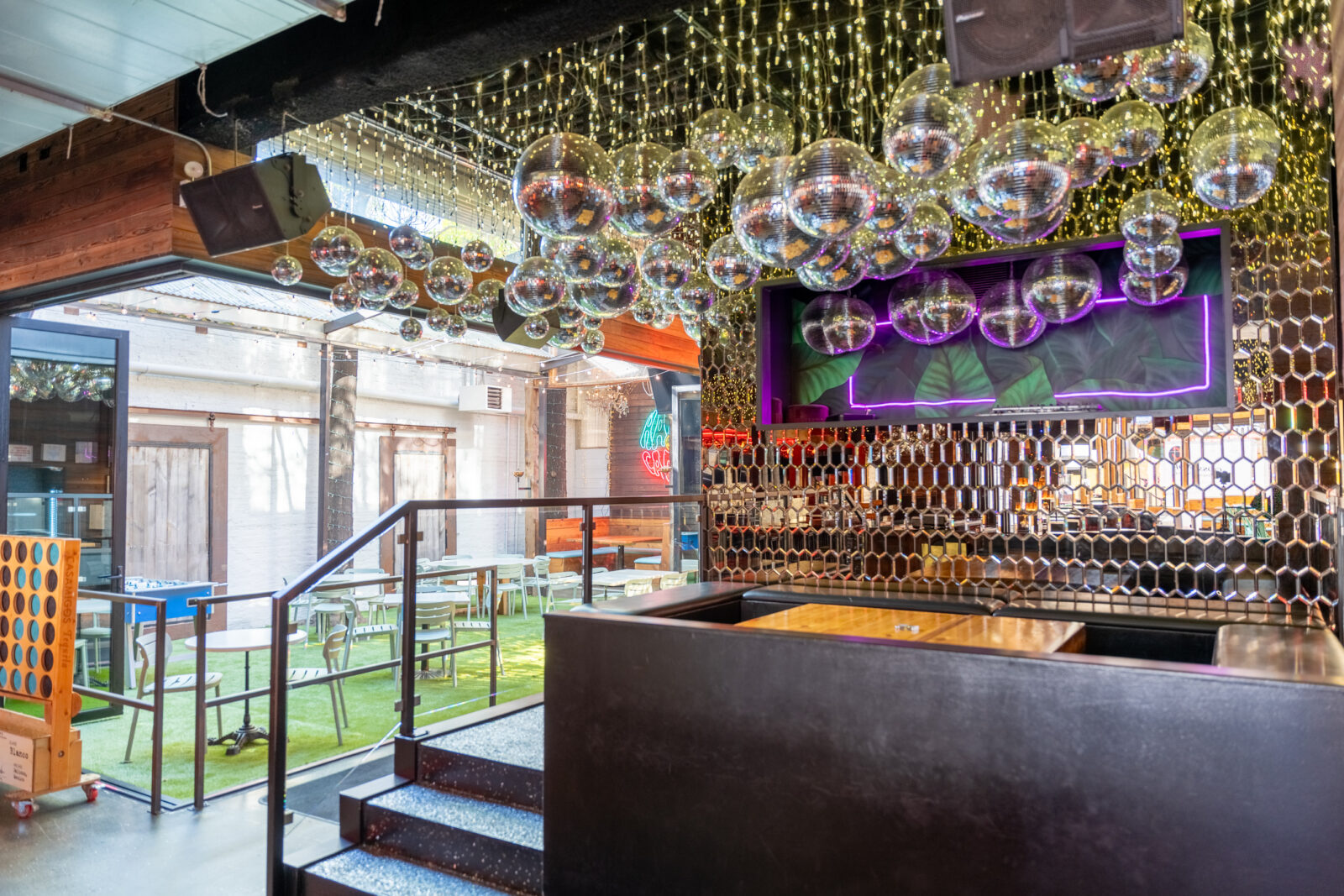 slide 1 of 1 - Stage in front of dj booth, booth seating with disco balls hanging above