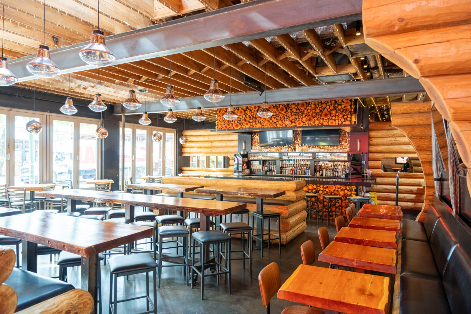 slide 4 of 5 - Restaurant inside and bar area, log cabin style design, high and low top seating, booths and bar stools