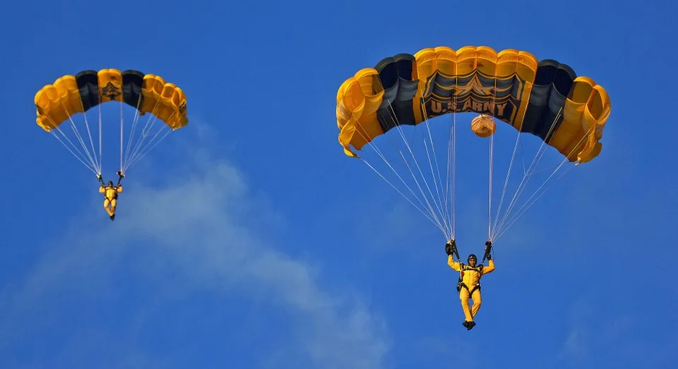 two people skydiving with opened parachutes