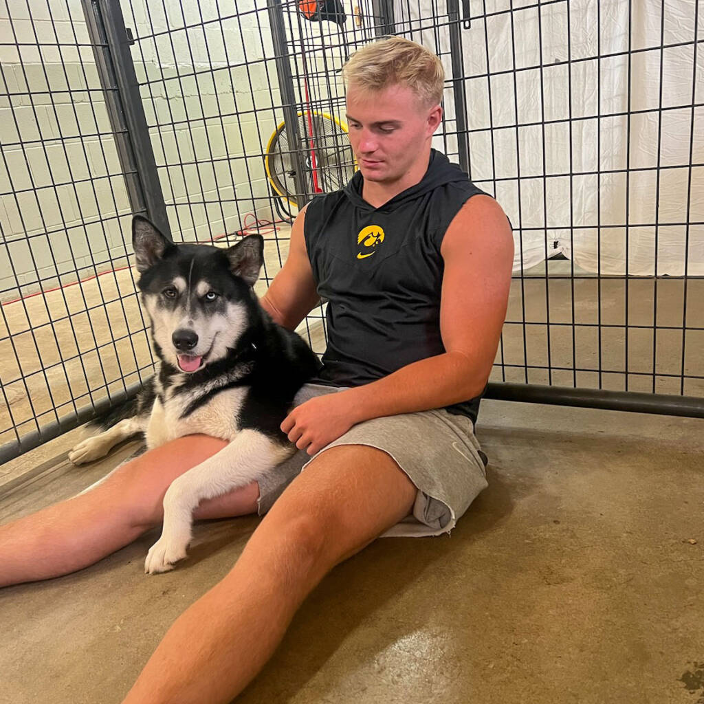 Man sits on the floor with a husky