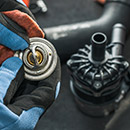 Technician hold a thermostat representing Climate Control Maintenance Parts Category