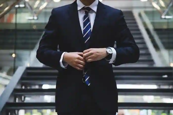 Man in suit buttoning himself