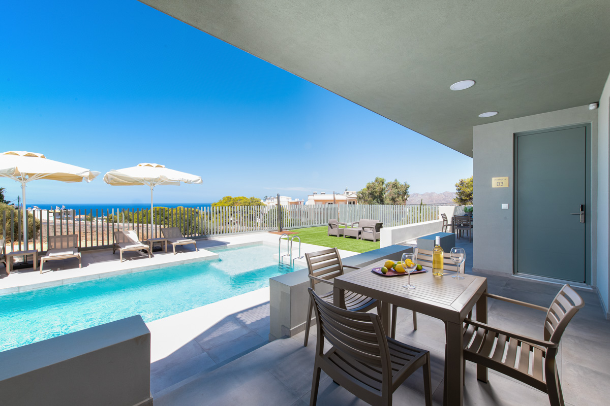 Exterior photo of accommodation, table under the shadow beside the pool