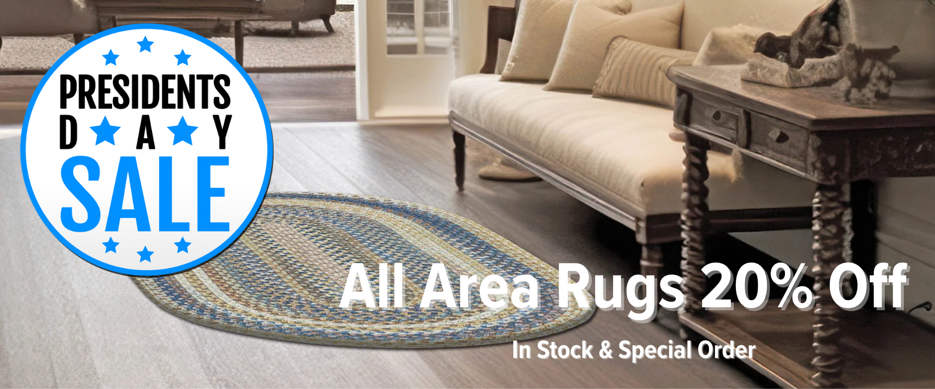 Earth-toned rectangular braided area rug with a concentric gradient pattern in a rustic living room setting featuring a wooden coffee table and tan sofa.