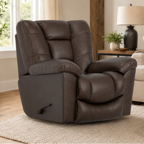 A light-toned wooden outdoor lounge chair with thick, cream-colored cushions sits on a stone paver patio. The chair features a modern, clean-lined frame with slightly tapered legs and curved armrests that showcase the natural grain of the wood.