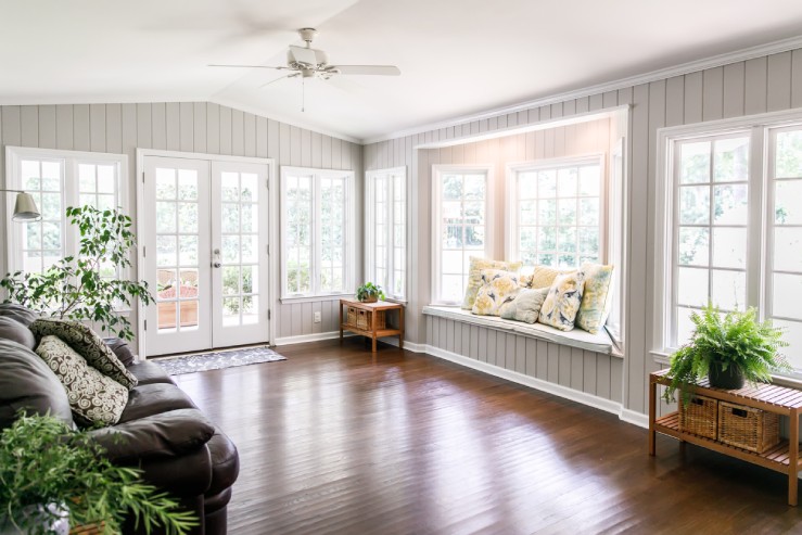 Sunlight pours through the window panes of an expansive sunroom. The room filled with light now feels open and inviting.