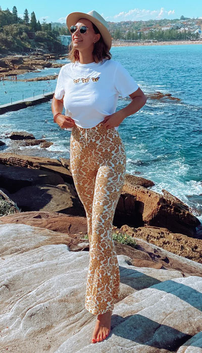Your summer wardrobe should consist of floral flare pants, a graphic tee, and a perfect beach hat. This is highly recommended for beach walks and strolling.