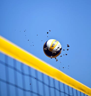 volleyball on the beach, net and yellow ball on blue sky