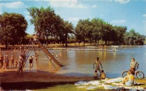 BEAVER DAM WISCONSIN CRYSTAL LAKE BEACH~SLIDING BOARD~BOY ON BIKE POSTCARD 1960s