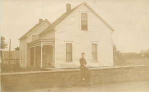 Postcard RPPC C-1910 Woman house Bicycle roadside 23-1258