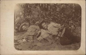 Unusual Men Laying in Field Guns Rifle Pistol Smoking Cigarettes c1910 RPPC
