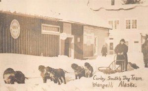 CURLEY SMITH'S DOG TEAM WRANGELL ALASKA OIL SIGN POSTCARD (c. 1910)