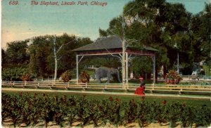 Chicago, Illinois - Woman walking by the Elephant at Lincoln Park - in 1913