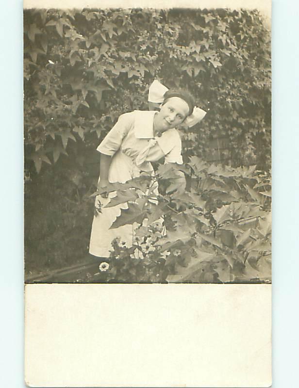 Pre-1918 rppc WOMAN WITH BOW IN HAIR BENDING OVER BY PLANTS r5836