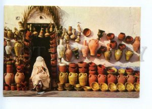 487012 Tunisia saleswoman of clay pots real posted to Yugoslavia postcard