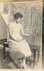 BEAUTIFUL YOUNG WOMAN IN STYLISH DRESS ADMIRING PHOTOGRAPH?~REAL PHOTO POSTCARD