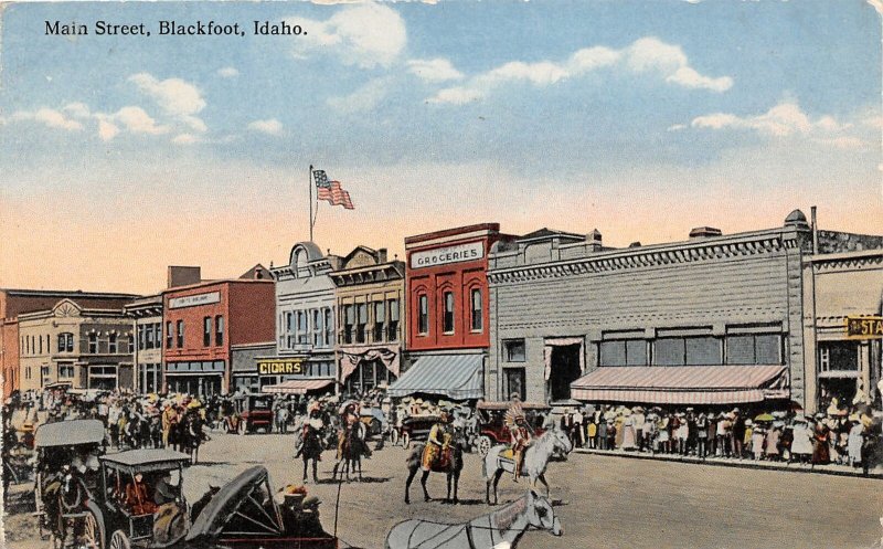 G17/ Blackfoot Idaho Postcard c1910 Main Street Parade Indians Stores