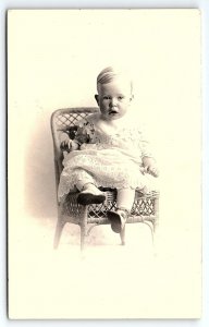 c1910 CUTE BABY IN WICKER CHAIR STUDIO PHOTO LACE DRESS AZO RPPC POSTCARD P3675