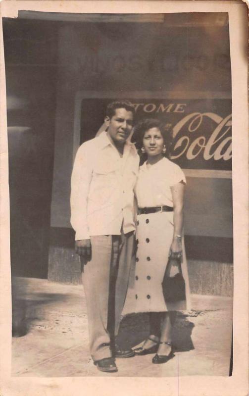 Unknown location man and woman in front of Coca Cola sign real photo pc Z18701