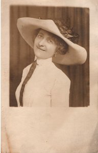 VINTAGE POSTCARD WOMAN IN PERIOD DRESS AND HAT SMILING REAL PHOTO DIVIDED BACK