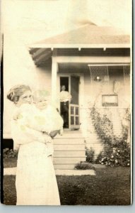 Vintage RPPC Postcard Woman holding a child, husband watching over POSTED 1915