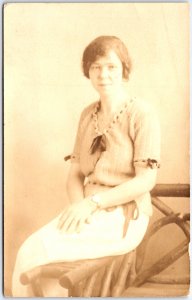 Woman in Lined Dress with Bows Sitting on Arm Chair Portrait - Vintage Postcard