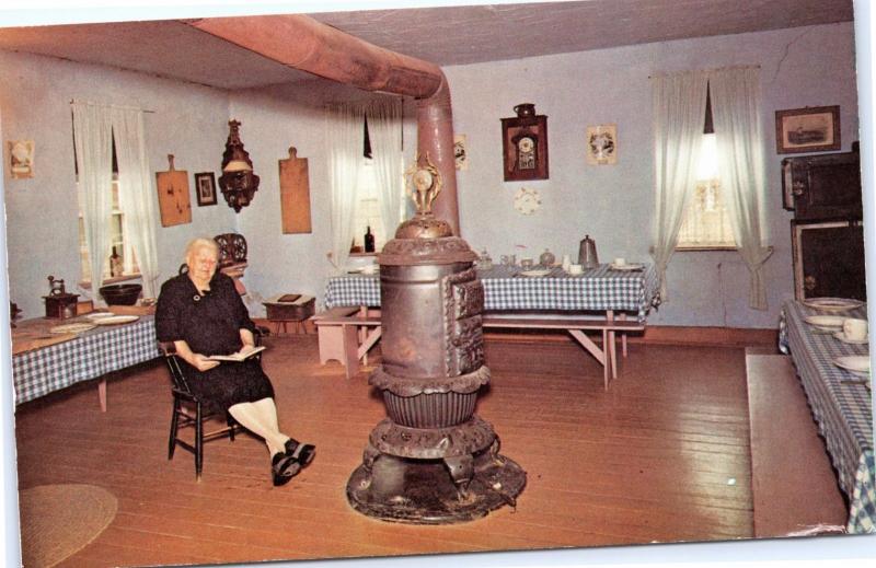 Colony Kitchen, Middle Amana, Iowa - Older Woman reading in front of stove