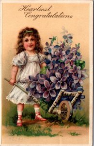 Heartiest Congratulations PC Little Girl Pushing Wheelbarrow of Purple Flowers