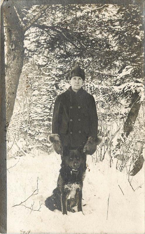 c1910s RPPC Postcard Man in Snow with Black Siberian Husky Type Dog unknown US