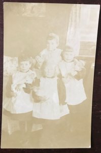 CHILDREN HOLDING DOLLS-REAL PHOTO POSTCARD