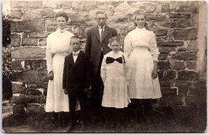 Family in Sunday Dress Clothes Along Stone Wall Portrait RPPC Vintage Postcard