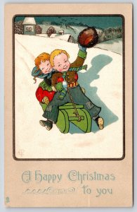 Christmas~Boy & Girl on Green Sled~Boy Tips Furry Russian Hat~Artist~1908 TUCK
