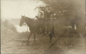 Trio of Men Sitting on Horse Drinking From Bottles c1910 Real Photo Postcard