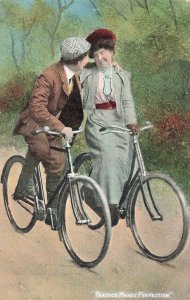 PRACTICE MAKES PERFECTION-MAN & WOMAN RIDING BICYCLES~BRITISH ROMANCE POSTCARD