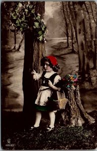1915 YOUNG GIRL WITH BASKET IN FORREST HAND TINT REAL PHOTO POSTCARD  17-8