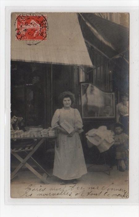 PARIS : carte photo d'une vendeuse de journaux devant un café (le Petit Pari...