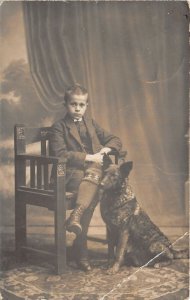 Ro625 child boy sitting on a chair and a dog greetings real photo romania Brasov