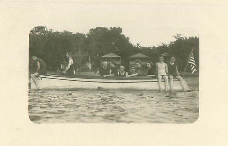 Men in Old Fashioned Swimsuits on Canoe, U S  Flag 1920s (?)  RPPC Postcard