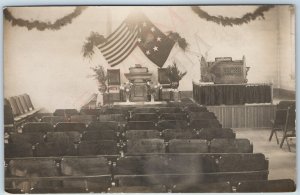 c1910s Unknown Event Room RPPC US Flag Seats Flowers Speaker Stage Ceremony A203