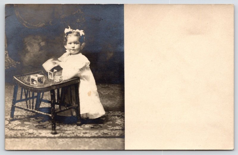 RPPC Toddler Slightly Annoyed by Photographer As She Plays w/Nesting Blocks 1910 