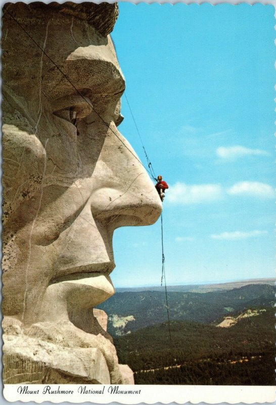 postcard SD - Mt. Rushmore - Man performing maintenance on Lincoln's face