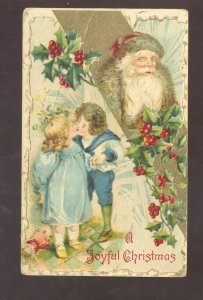 A JOYFUL CHRISTMAS SANTA CLAUS BROWN ROBE CHILDREN KISSING OLD POSTCARD