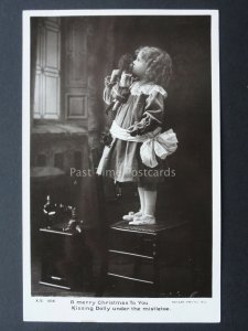 Christmas LITTLE GIRL KISSING HER DOLLY BY MISTLETOE c1906 RP Postcard by Rotary