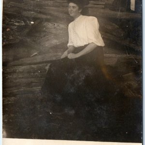 c1910s Weird Edwardian Woman Sits in Wood Pile RPPC Creepy Smile Real Photo A140