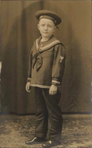 Little Boy in Studio Sailor Hat Socumte DEMOCRACY on Cap c1920 RPPC Postcard