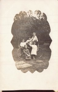 LOTS OF KIDS CHILDREN AROUND A BICYCLE ~1910s REAL PHOTO POSTCARD