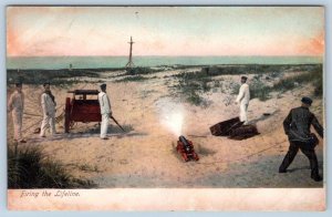 Pre-1907 FIRING THE LIFELINE LIFE SAVING LIFEGUARDS SAILORS BEACH SCENE POSTCARD