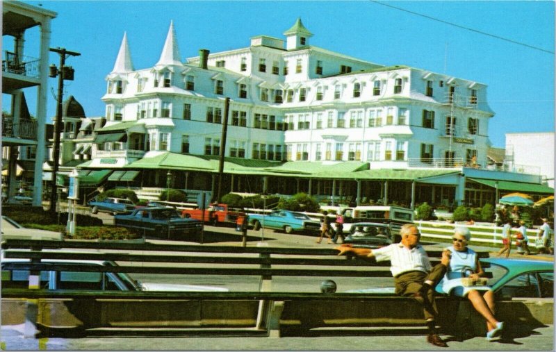 Cape May, NJ - Older couple sitting on beach with Victorian Architecture resort